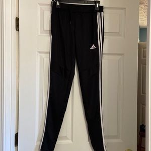 Black adidas soccer pants with white strips.